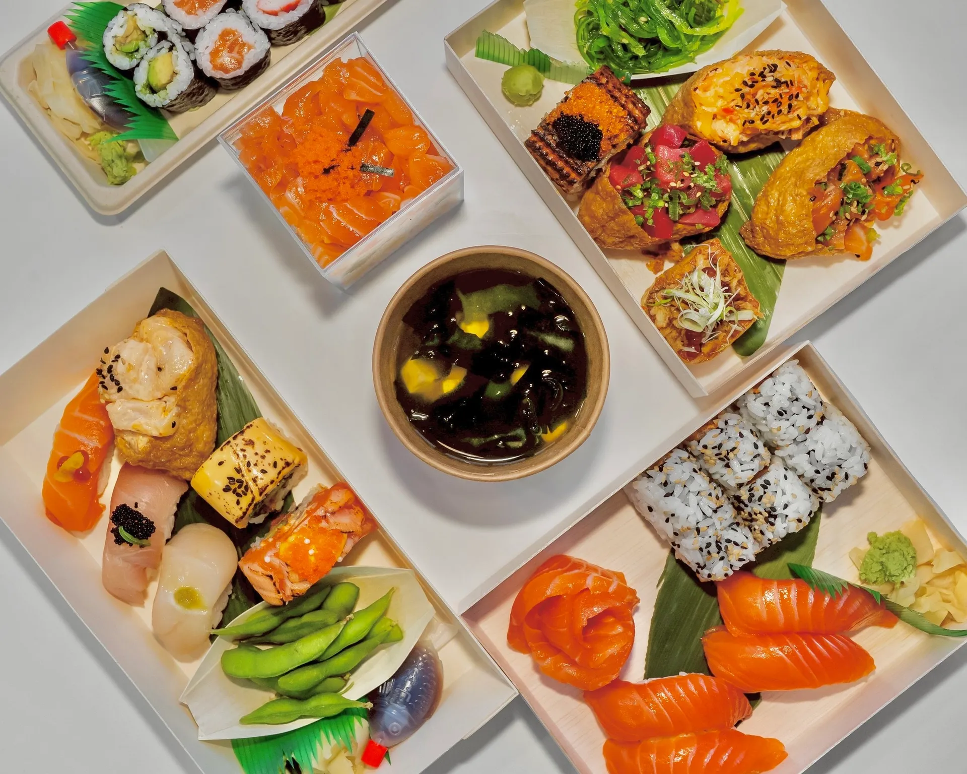 Overhead spread of All Buru sushi boxes, sashimi, inari and miso soup